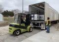 Workers loading helmets and ballistic vests headed to Ukraine into a truck at Camp Dodge in Johnston, Iowa.