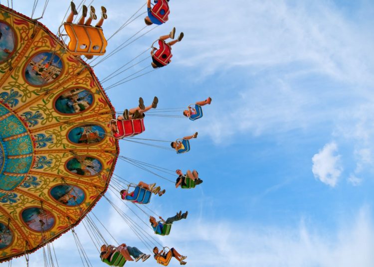 people riding carousel in park