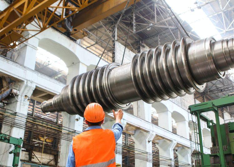 man standing beside heavy equipment