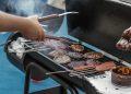 person grilling sausage and meat