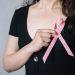 woman holding pink ribbon